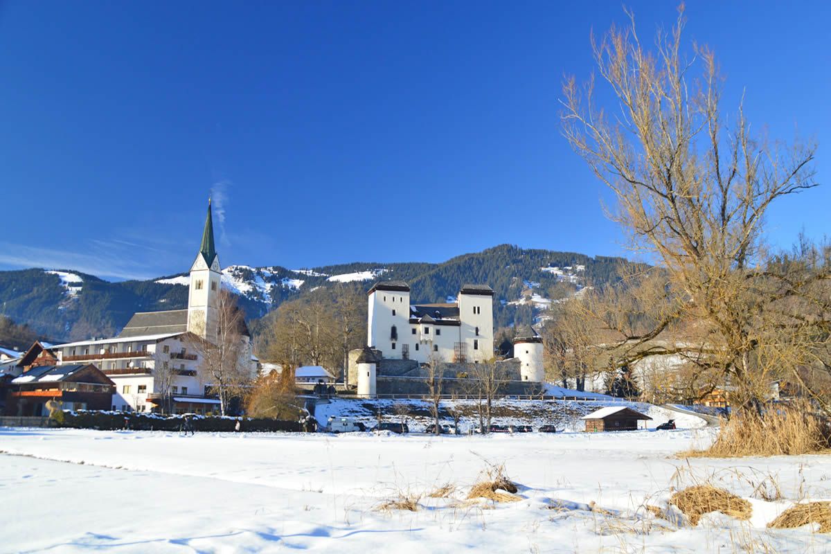 Blick über den zugefrorenen Goldegger See zum Schloss Goldegg